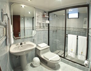 A modern bathroom with a sink, toilet, and glass-enclosed shower.