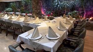 A long dining table set with white tablecloths, napkins, and silverware, surrounded by leather chairs. - Hotel Centro Internacional (Bogotá)