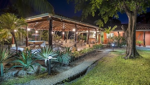 A covered outdoor area with seating, a pathway, and tropical plants. - Bahia Esmeralda Boutique Hotel & Villas (Tempate)