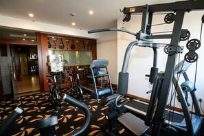 A fitness center with exercise equipment, including treadmills and weight machines. - Bremen Hotel (Harbin)