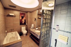 A modern bathroom with a bathtub, toilet, and shower area.