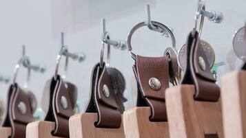 Une rangée de porte-clés en bois, chacun portant un numéro, un porte-clés en métal et une plaque avec une lettre.