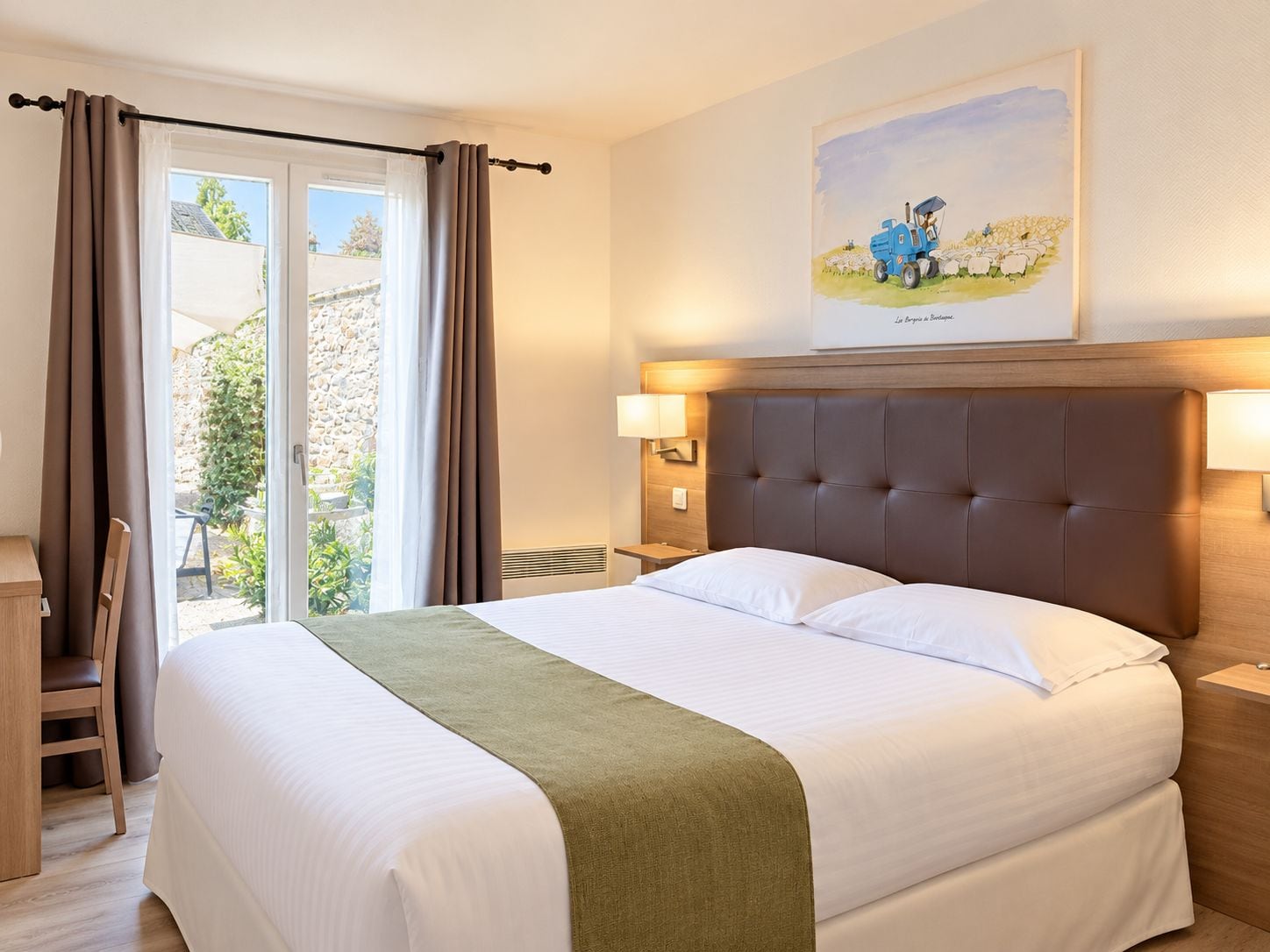 Une chambre d’hôtel avec un grand lit, un bureau et une fenêtre avec des rideaux.