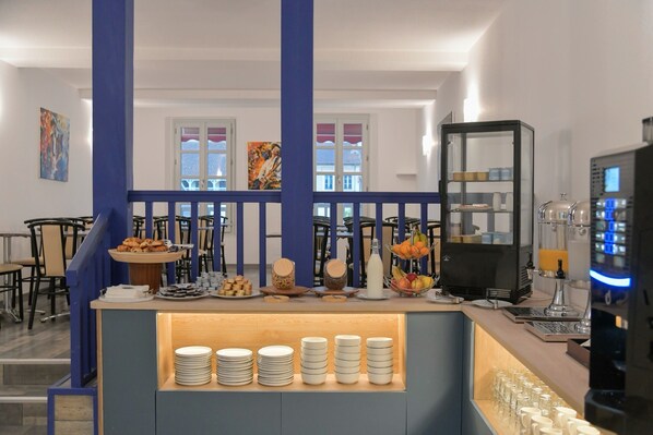 A breakfast bar with plates, bowls, and a coffee machine.