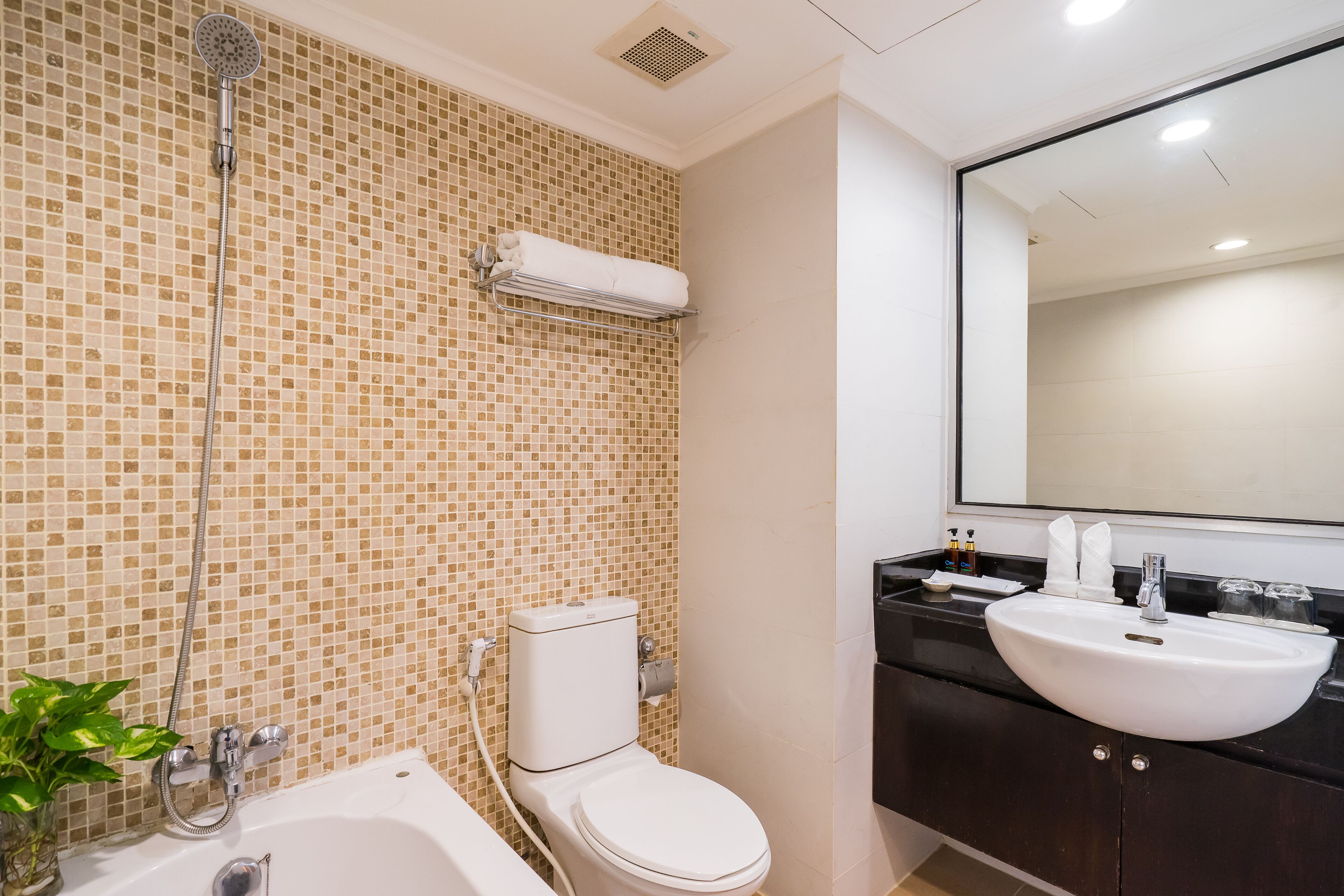 A bathroom with a toilet, shower, and sink.