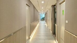 A hotel hallway with a long, straight corridor, doors on both sides, and a visible elevator. - Citin Pratunam Bangkok Hotel by Compass Hospitality (Bangkok)