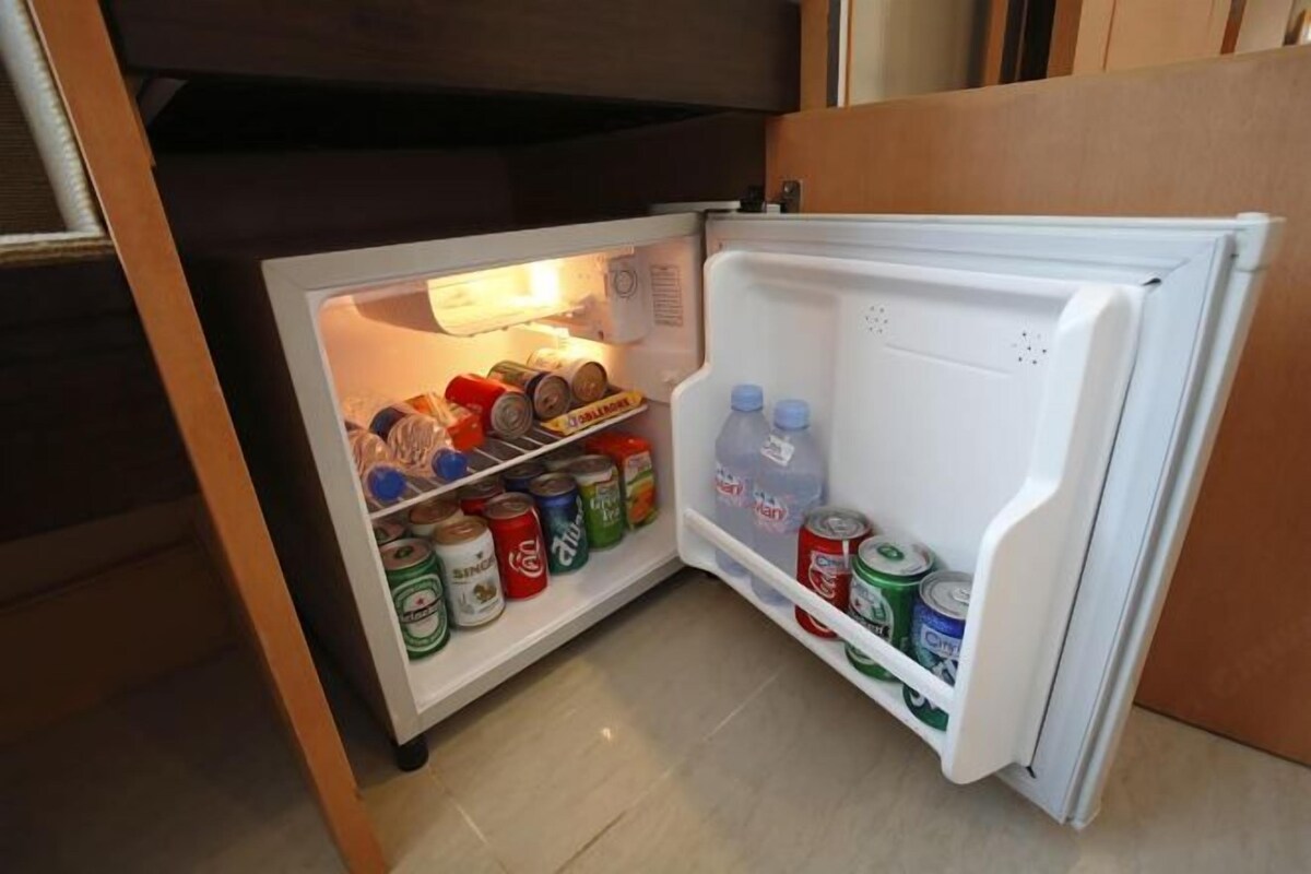 Un refrigerador pequeño con bebidas y alimentos enlatados.