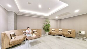 A modern living room with two sofas, a coffee table, and a potted plant. - Citin Pratunam Bangkok Hotel by Compass Hospitality (Bangkok)