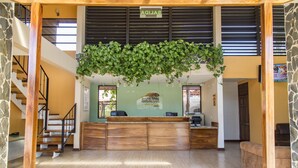 A reception area with a wooden desk, a staircase, and a hanging plant. - Nacazcol Hotel and Villas (Sardinal)