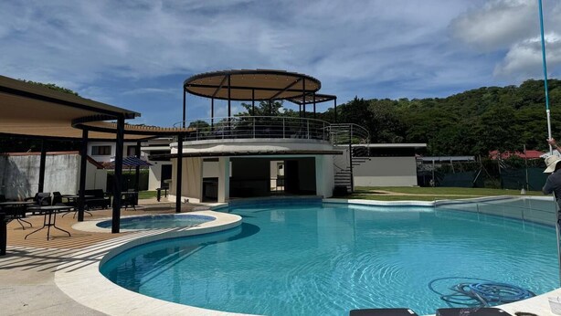 A swimming pool with a covered area and a patio with seating. - Nacazcol Hotel and Villas (Sardinal)
