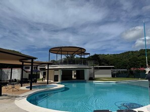 Piscina con zona techada y patio amoblado.
