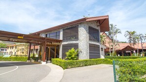 A modern building with a stone facade, large windows, and a covered entrance area. - Nacazcol Hotel and Villas (Sardinal)