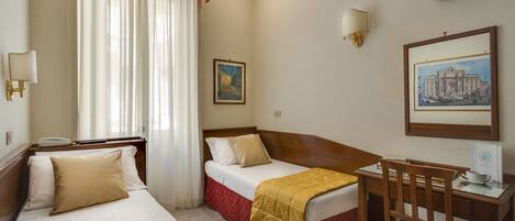 Habitación de hotel con dos camas, un escritorio, una silla, un televisor y un cuadro en la pared.