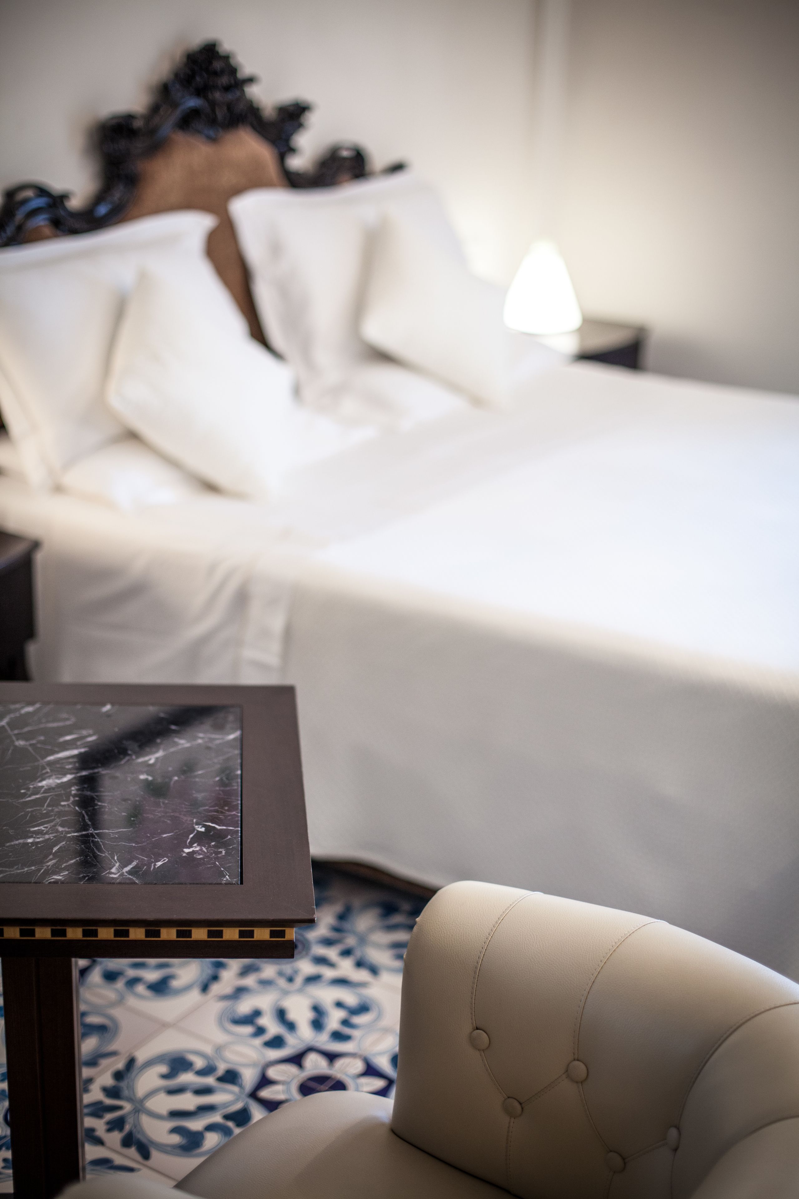 Ein Hotelzimmer mit Bett, Nachttisch und Stuhl.