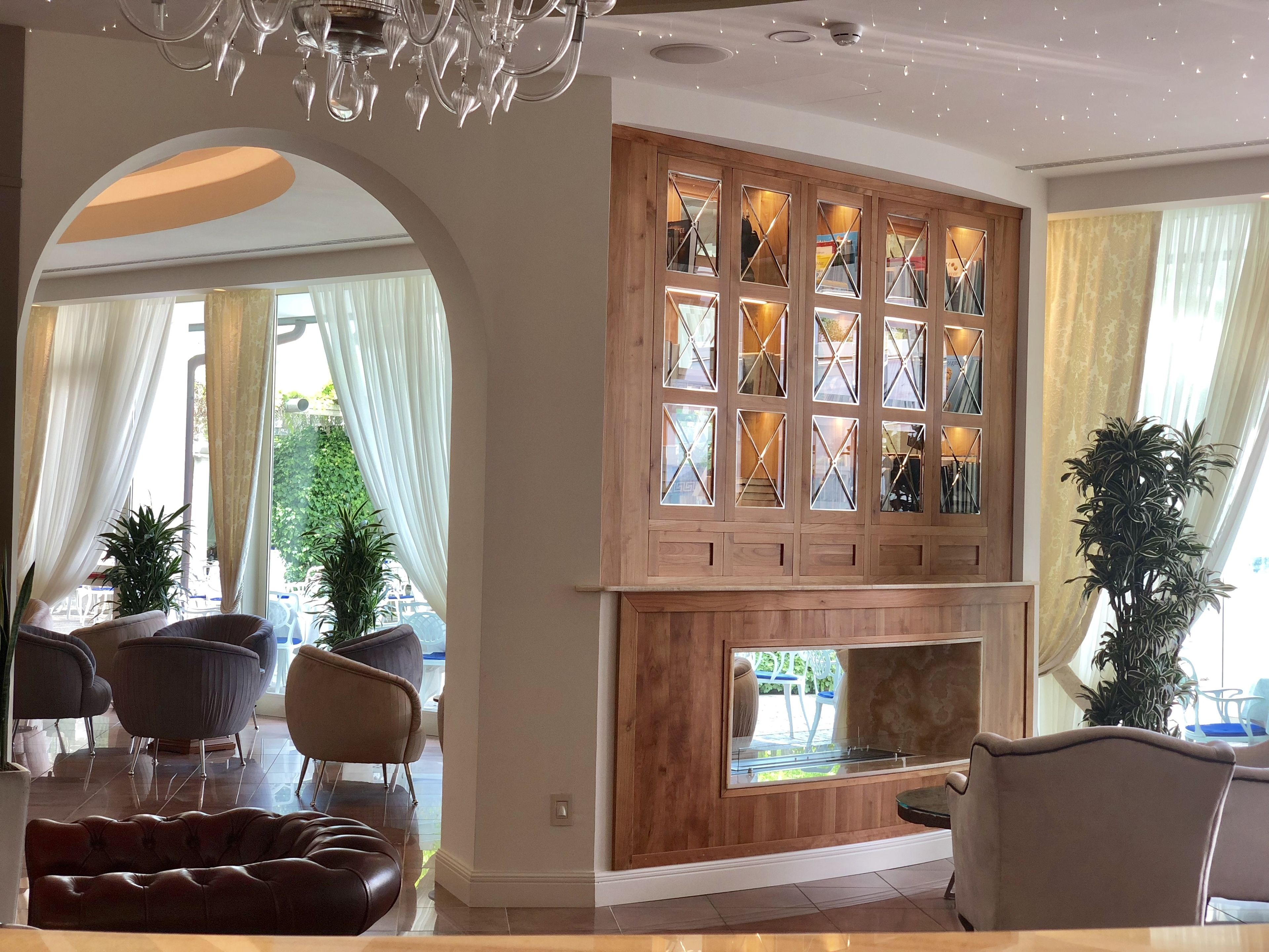 A modern living room with a fireplace, comfortable seating, and large windows.
