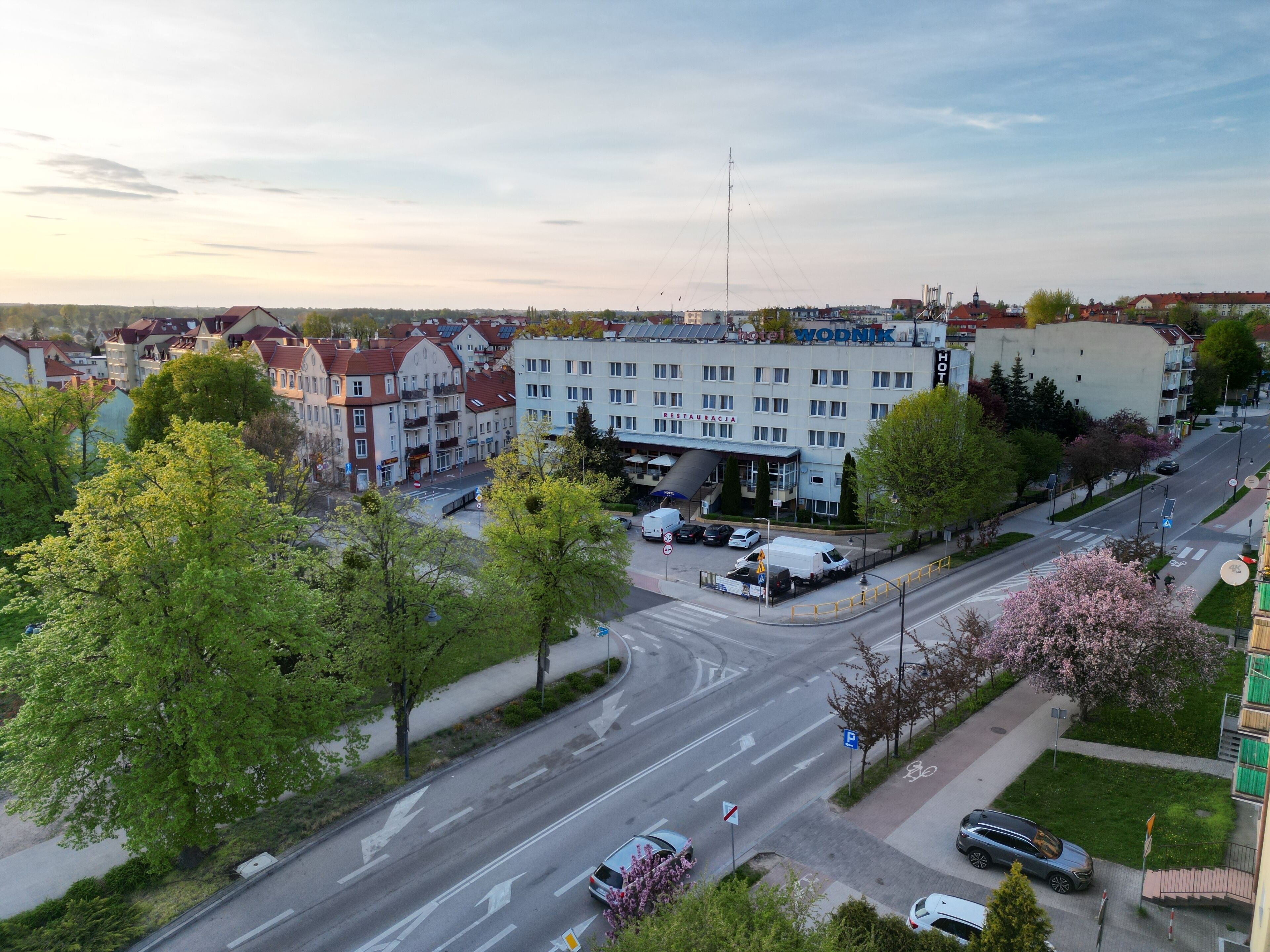 Un albergo con ristorante, diversi piani e un'area parcheggio.