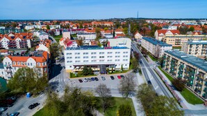 A hotel with a central courtyard, multiple floors, and a parking lot. - Hotel Wodnik (Gizycko)