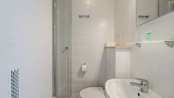 Un baño con inodoro, lavamanos y ducha.