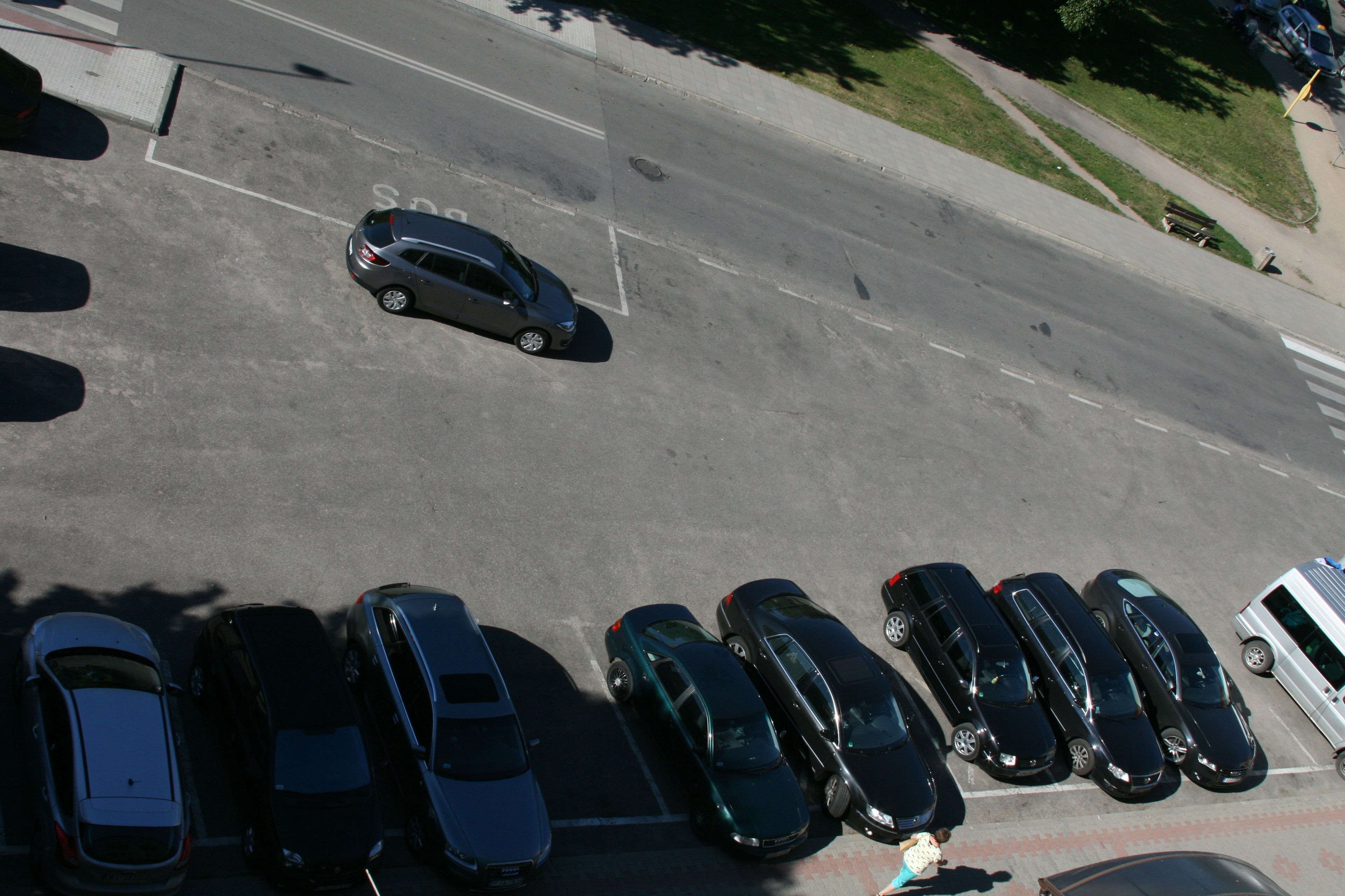 An aerial view of a parking lot with multiple cars parked in rows.
