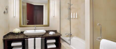 A modern bathroom with a large sink, vanity, and a walk-in shower.