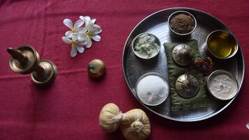 A tray with various items including a flower, a metal cup, and containers of different substances.