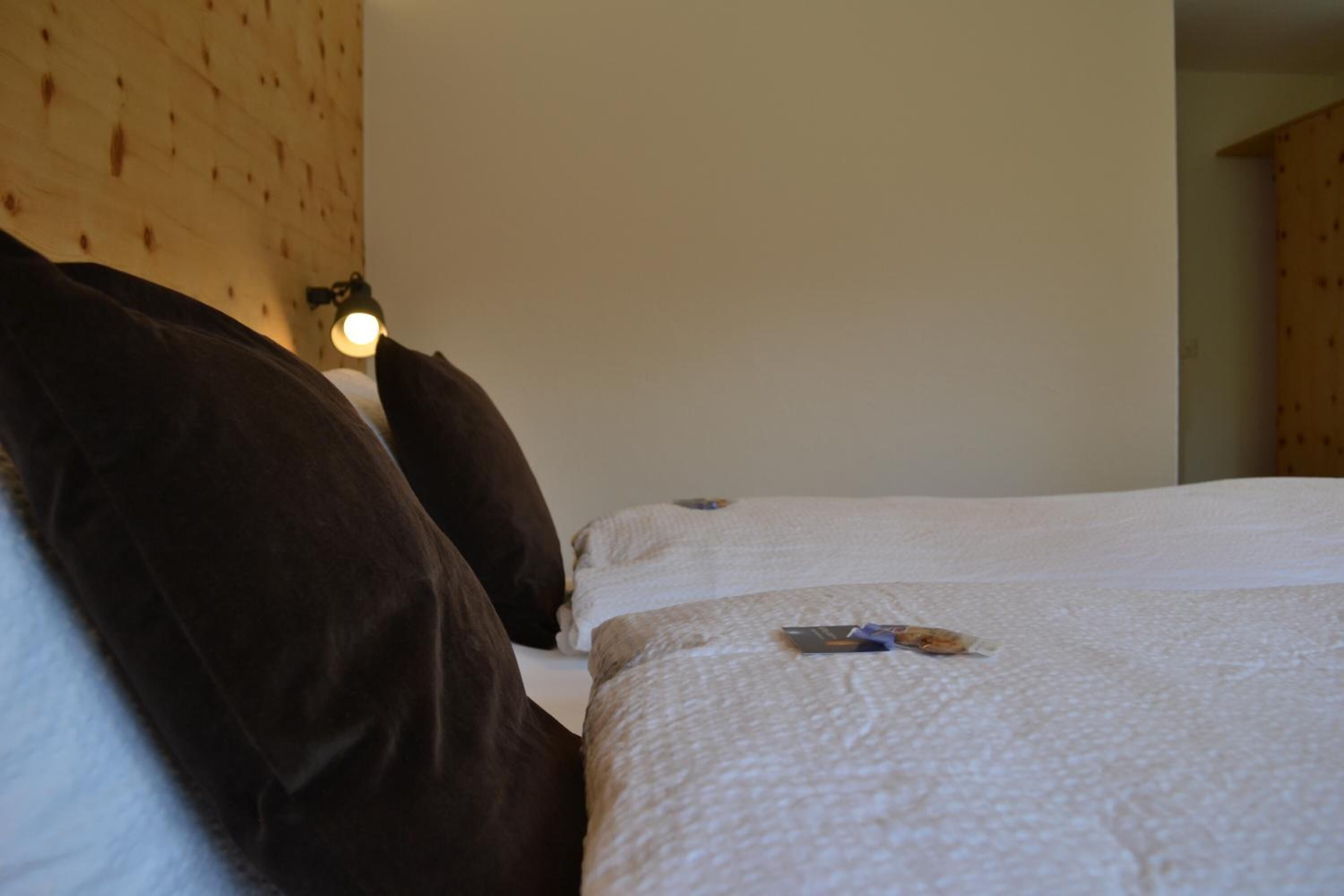 Habitación de hotel con dos camas, un muro de madera y una luz nocturna.