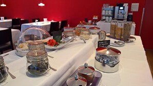 A buffet setup with various food items and condiments. - Schorta's Hotel Alvetern (Scuol)
