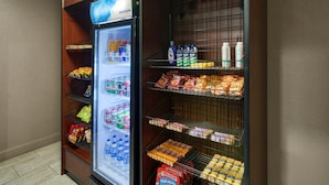 A refrigerated display case with beverages and snacks, and a shelf with bottled water and other beverages. - Best Western Waldo Inn and Suites (Waldo)