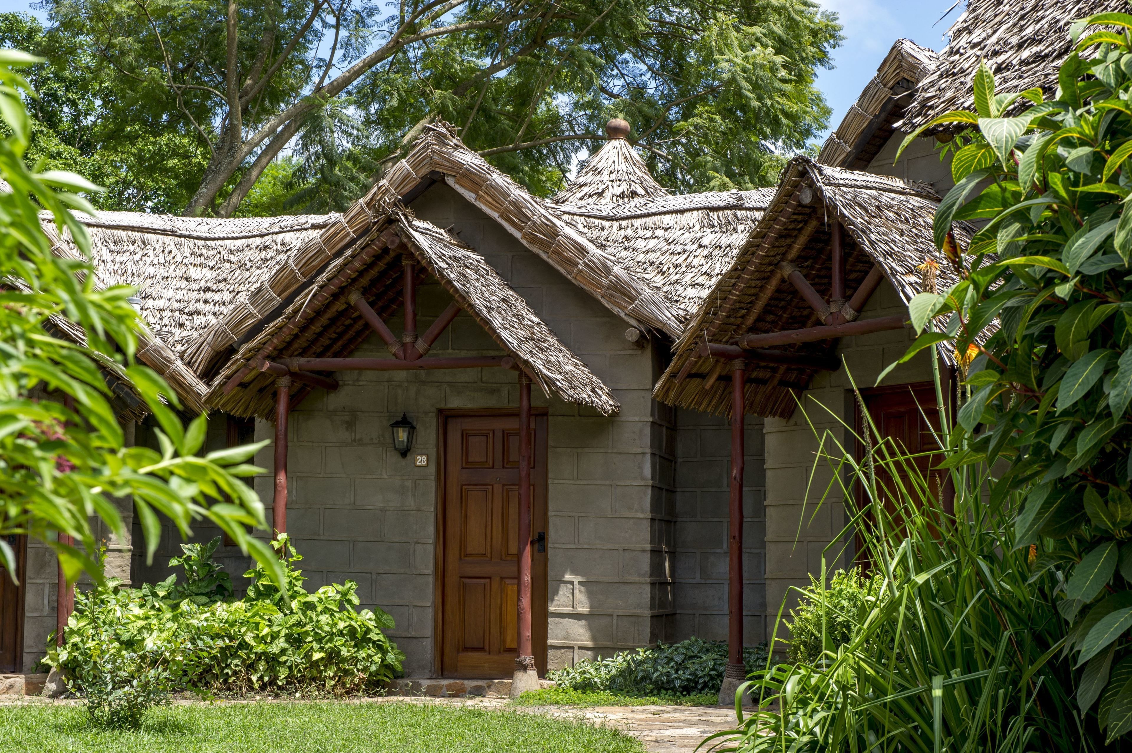 Une maison traditionnelle à toit de chaume, avec une porte en bois et un mur en pierre.