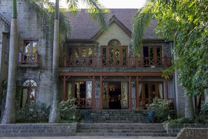 A two-story stone building with a balcony, large windows, and a staircase leading to the entrance. - Arusha Serena Hotel (Arusha)