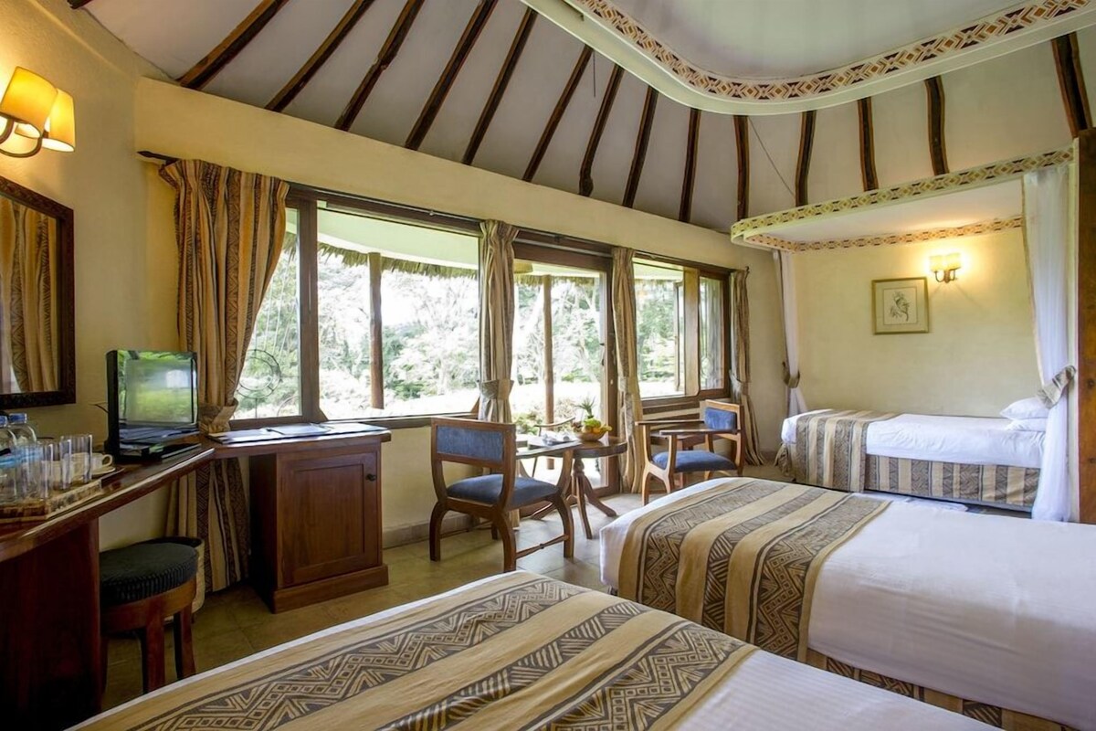 Habitación de hotel con dos camas, un escritorio con computadora y una ventana con cortinas.