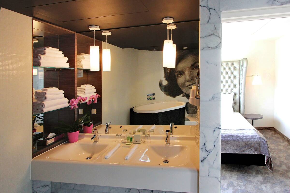Un baño moderno con un espejo grande, dos lavamanos y una zona de tocador.