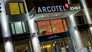 Exterior del edificio ARCOTEL JOHN F, con un cartel que anuncia el Restaurante Asuntos Exteriores.