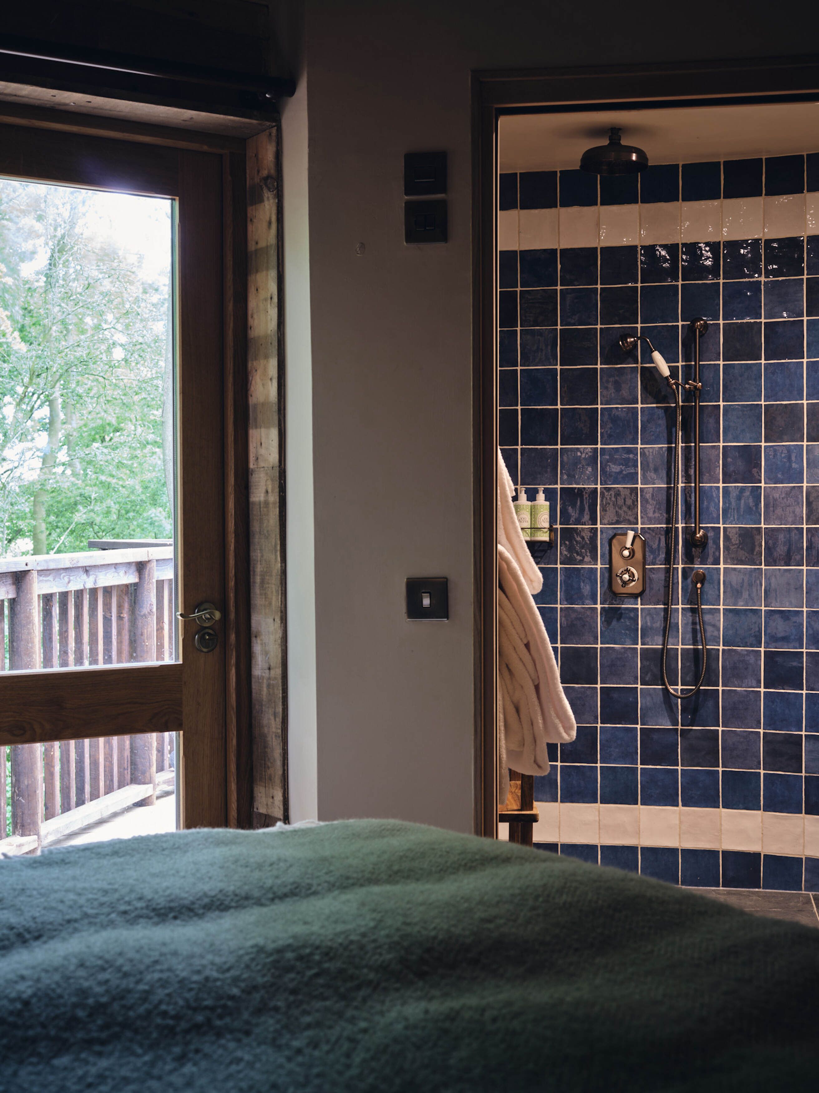 Une salle de bain avec une douche, un porte-serviettes et une vue sur l’extérieur.