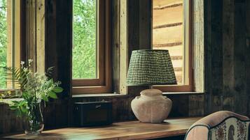 Una scrivania in legno con una lampada, una sedia e un vaso di fiori.