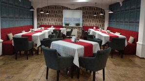 A dining area with multiple tables and chairs, a red and white color scheme, and a patterned wall. - Villa Natali (Chisinau)