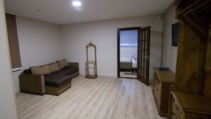 A room with a sofa, a wooden cabinet, and a mirror. - Villa Natali (Chisinau)