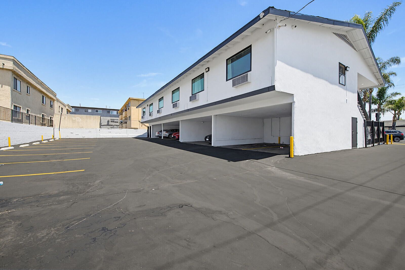 A parking lot with a building that has multiple parking spaces and a covered area.