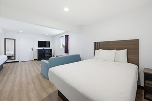 A hotel room with a large bed, a sofa, a TV, a desk, and a wardrobe. - Hyland Motel Van Nuys (Van Nuys)