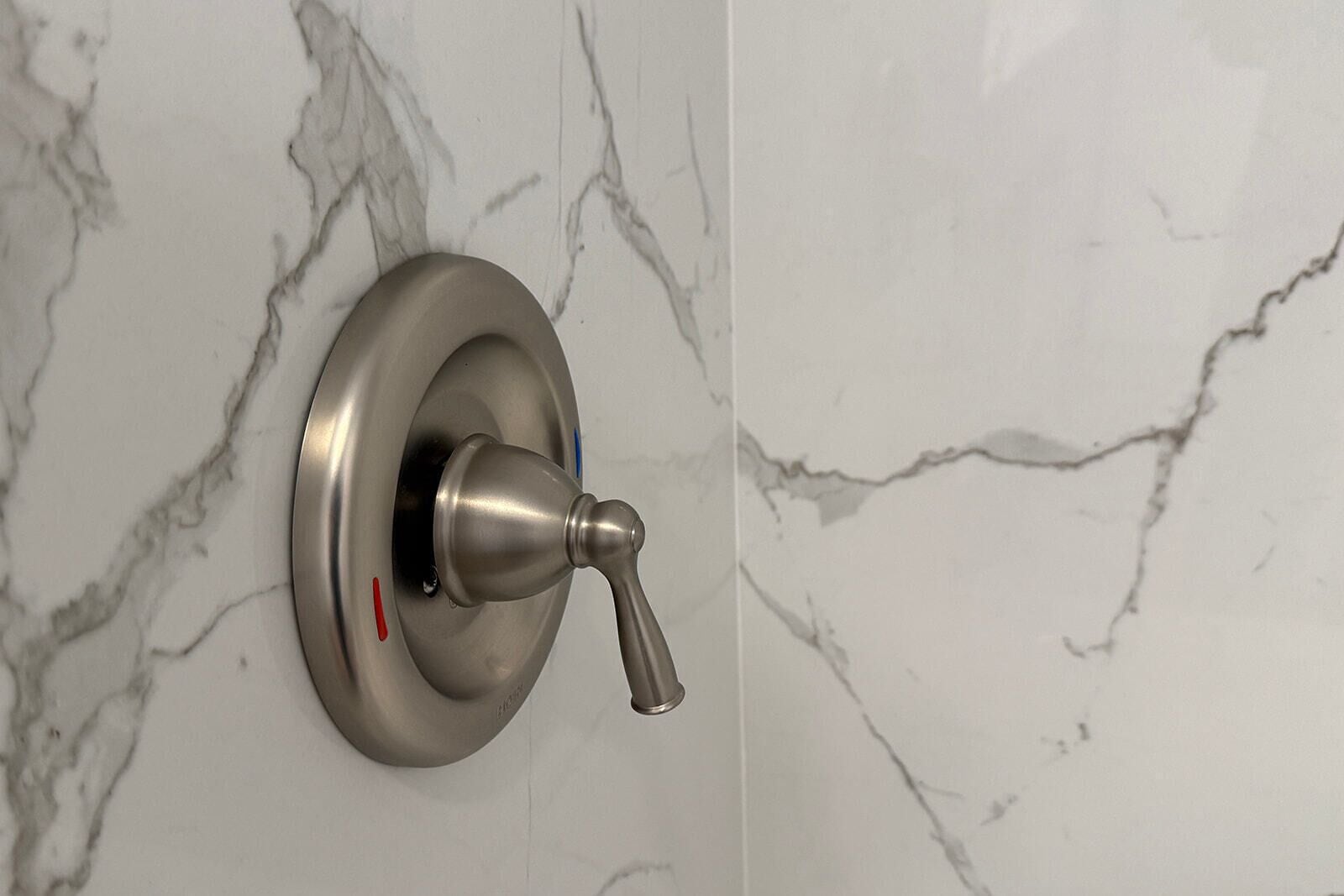 A bathroom door with a metallic handle and a circular lock mechanism.