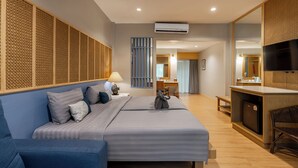 Une chambre d’hôtel comprenant un lit, un bureau, une télévision et un coin salon.