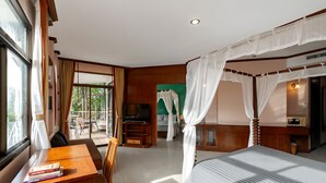 Une chambre d’hôtel avec un lit, une télévision, un bureau avec des livres et une vue sur l’extérieur.