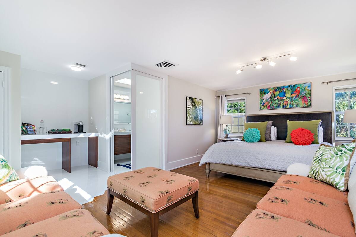 Une chambre moderne avec un lit, un bureau et un coin salon.