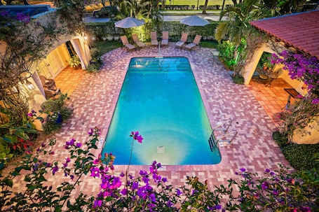 Una piscina al aire libre, sillones reclinables de piscina