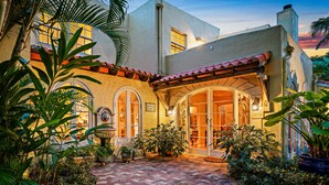A hotel with a courtyard, arched windows, and a tiled roof.