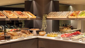 A buffet with various food items including pastries, bread, donuts, and fresh fruits. - Hotel Denit Barcelona (Barcelona)