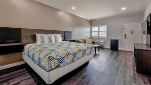 A modern hotel room with a large bed, a desk, a TV, and a wardrobe. - Motel 6 South Gate, CA (South Gate)