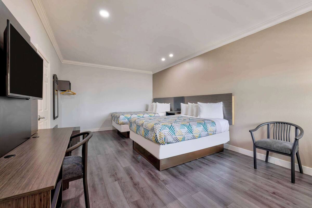 A hotel room with a bed, a desk, and a chair.