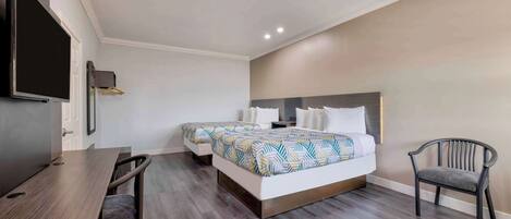 A hotel room with a bed, a desk, and a chair.