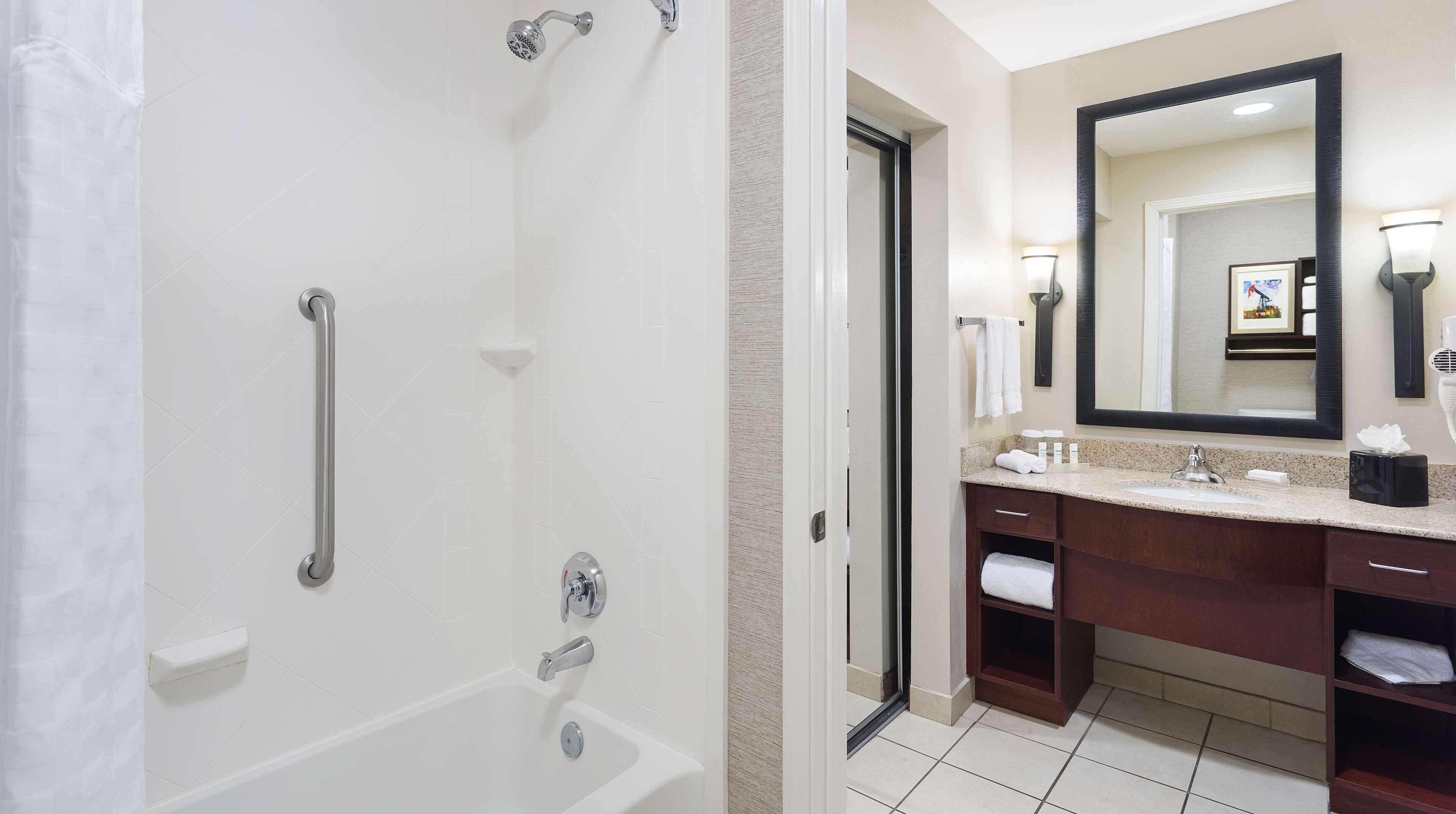 Un baño moderno con cabina de ducha, tocador con espejo grande y bañera.